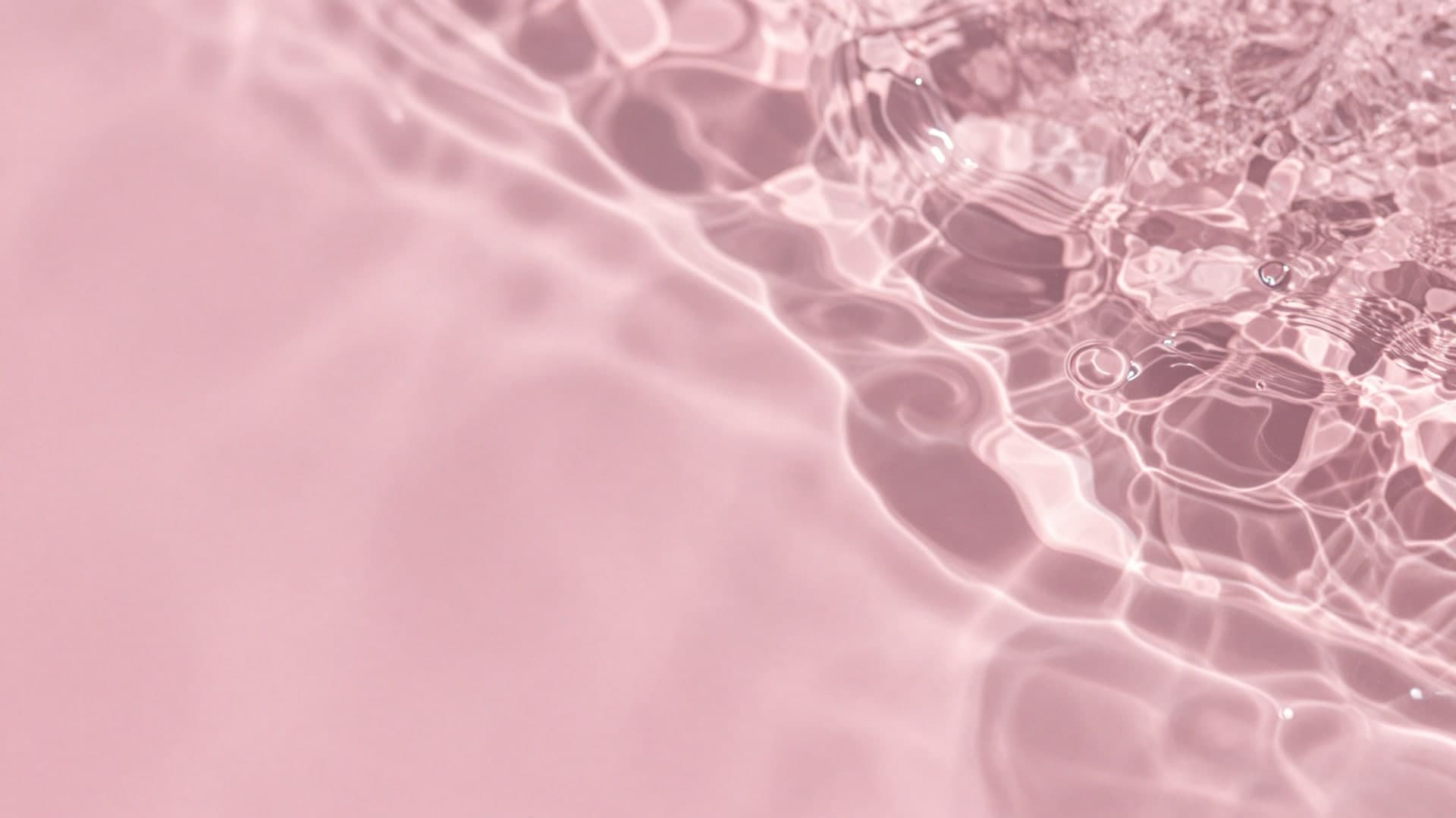 Soft rippling pink liquid texture forming abstract patterns.
