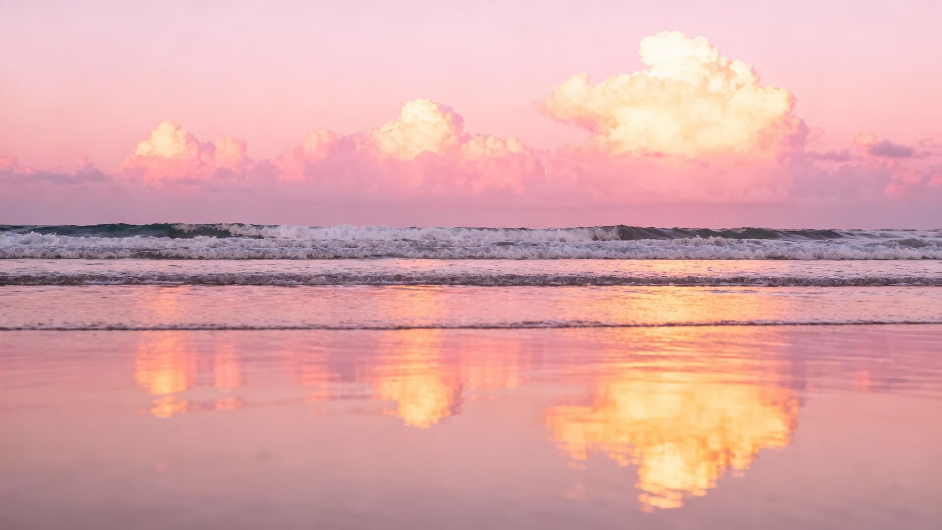romantic pink sunset reflecting across gentle ocean waves